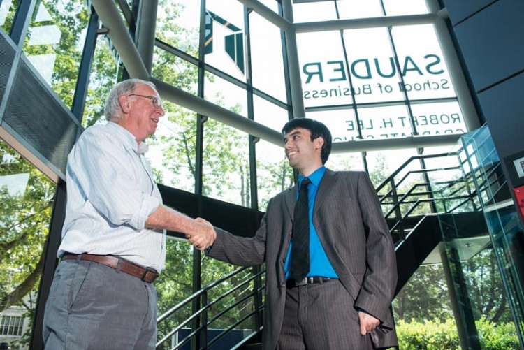 2 Men shaking hands at the Sauder building